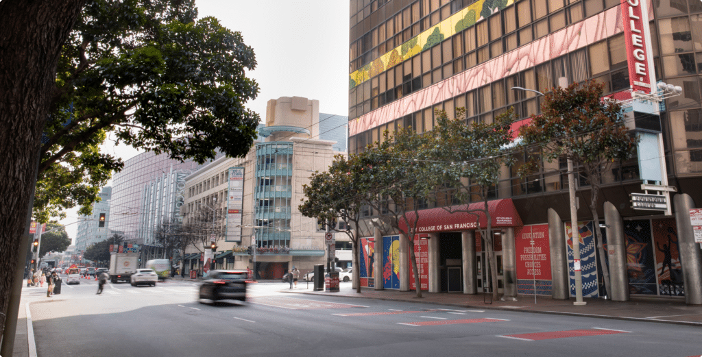 Street view of a downtown San Francisco building with colorful art wrapping across its facade