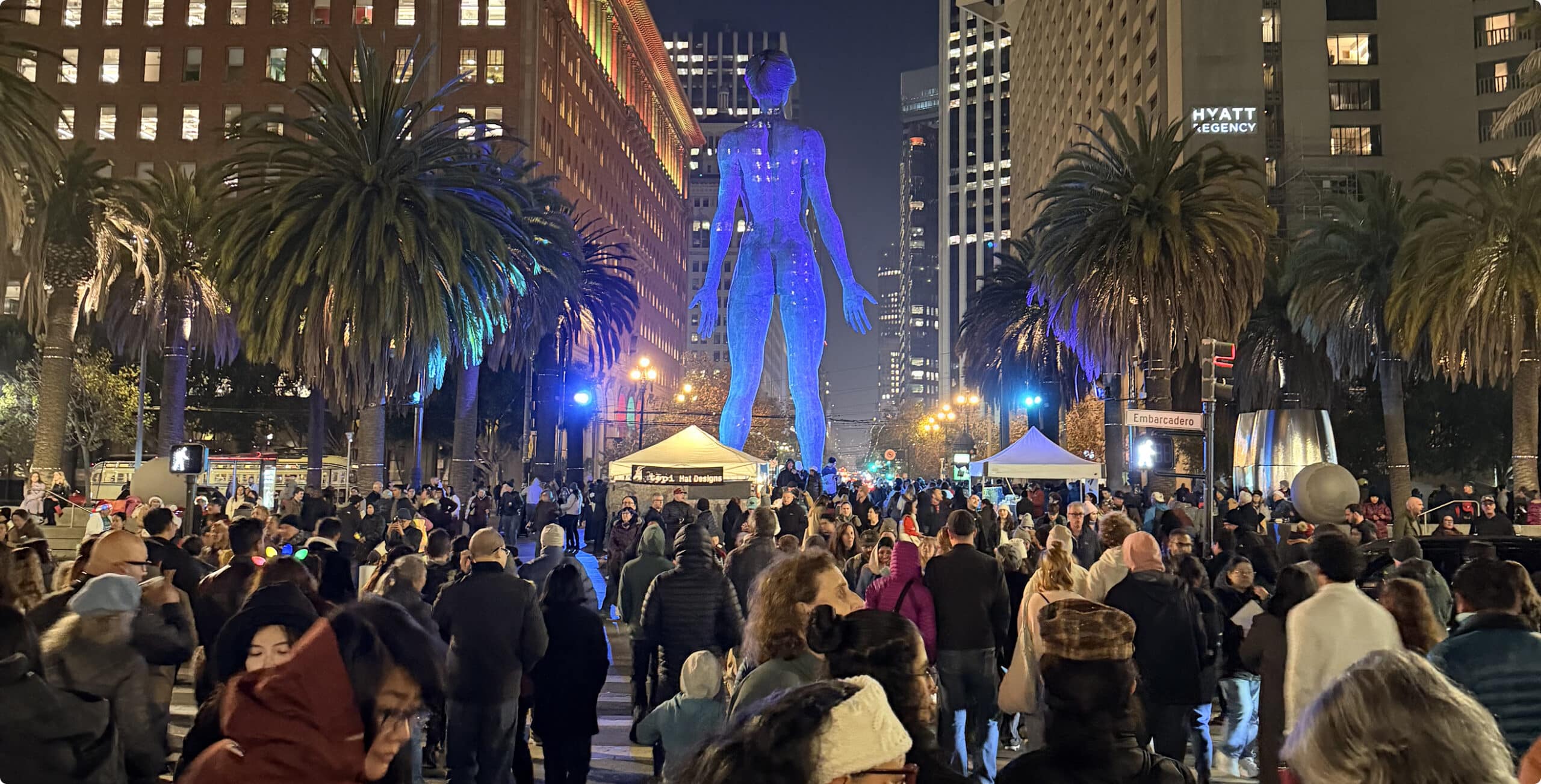 Crowd gathered around illuminated public art installation at night in downtown San Francisco
