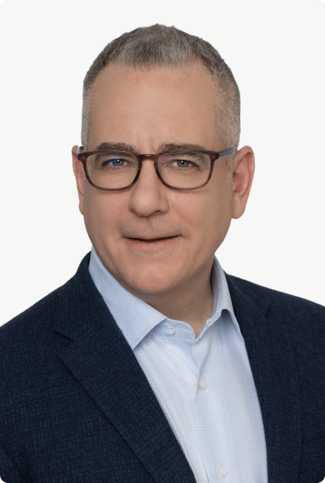 Man wearing glasses in a professional headshot against a neutral background