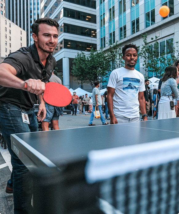 People playing ping pong outdoors in a downtown San Francisco plaza