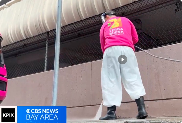 Worker cleaning a wall with a pressure washer near Yerba Buena in downtown San Francisco