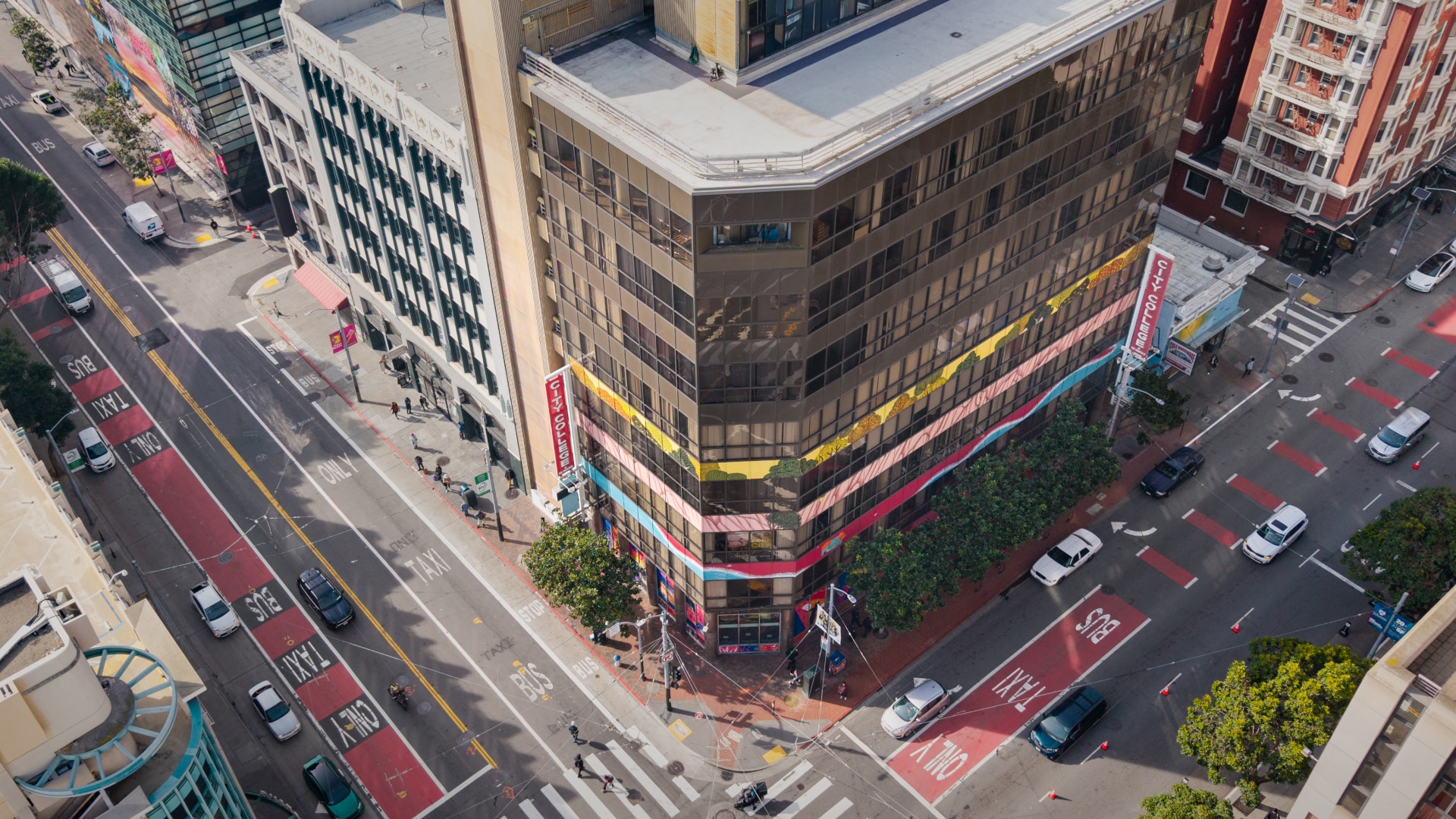 Aerial view of a downtown San Francisco intersection with bus lanes and surrounding buildings