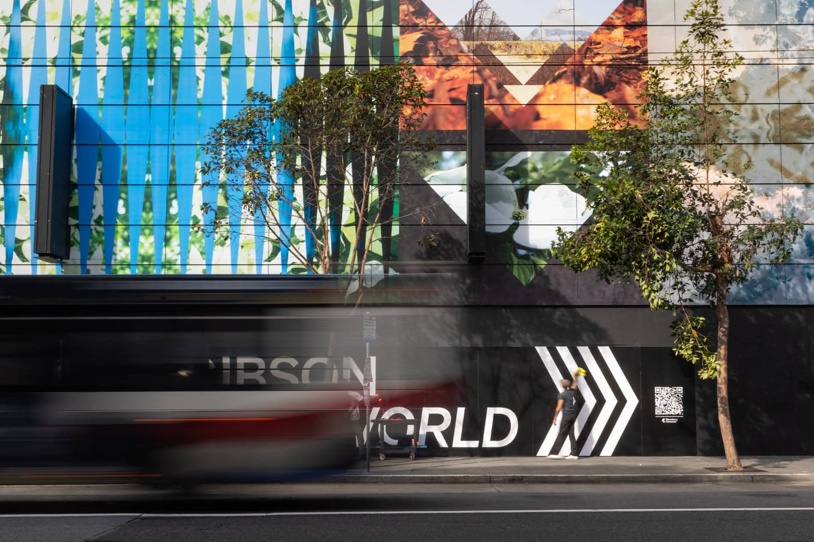 Colorful mural on a downtown San Francisco building with a bus passing in the foreground